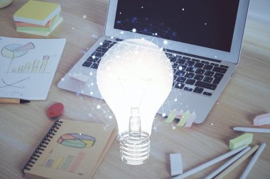Bilgisayar ofisinde ampul simgesi hologramıyla birlikte. Çoklu maruz kalma. Fikir kavramı.