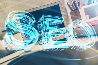 Bilgisayar ve seo çizim hologramı olan bir masanın çifte görüntüsü. Arama optimizasyon kavramı.