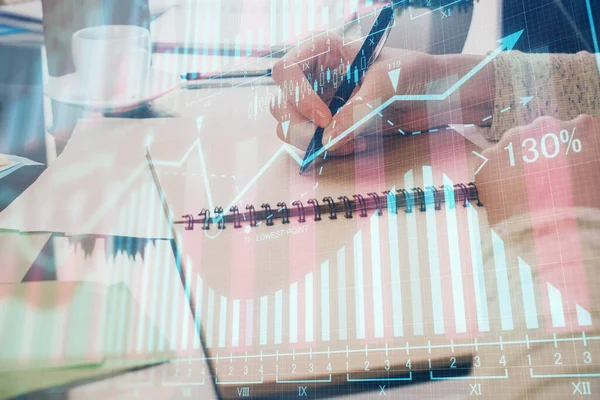 Toma de notas a mano en bloc de notas. Hologramas gráfico de divisas en frente. Concepto de investigación. Doble exposición —  Fotos de Stock