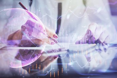 Bir kadın eller Not defteri hisse senedi piyasası hakkında bilgi yazma. Ön Forex grafik hologramlar. Araştırma konsepti.