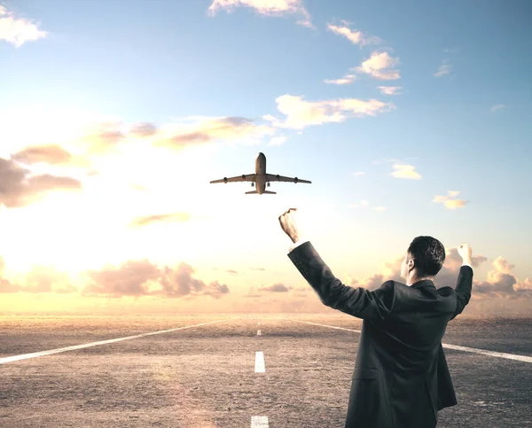 滑走路に立つ幸せなビジネスマンと空を飛ぶ飛行機 旅行と休暇のコンセプト — ストック写真
