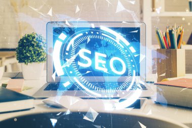 Bilgisayar ve seo çizim hologramı olan bir masanın çifte görüntüsü. Arama optimizasyon kavramı.