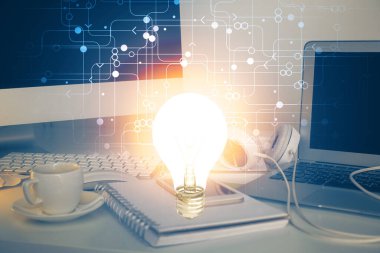 Bilgisayar ofisinde ampul simgesi hologramıyla birlikte. Çoklu maruz kalma. Fikir kavramı.