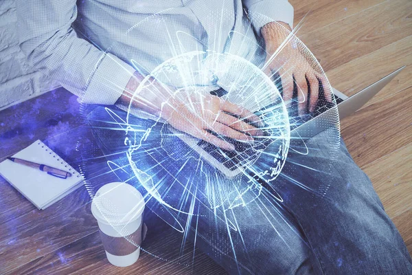 Doppelentblößung des Geschäftsmannes, der am Laptop im Hintergrund arbeitet. internationales Business-Hologramm vorn. Erfolgskonzept. — Stockfoto