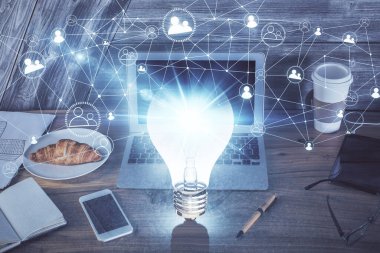 Bilgisayar ofisinde ampul simgesi hologramıyla birlikte. Çoklu maruz kalma. Fikir kavramı.