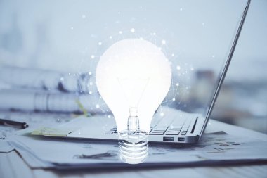 Bilgisayar ofisinde ampul simgesi hologramıyla birlikte. Çoklu maruz kalma. Fikir kavramı.