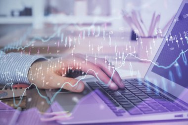 Arka planda dizüstü bilgisayar üzerinde çalışan adam ile borsa grafiği çift pozlama. Finansal analiz kavramı.