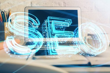 Bilgisayar ve seo çizim hologramı olan bir masanın çifte görüntüsü. Arama optimizasyon kavramı.