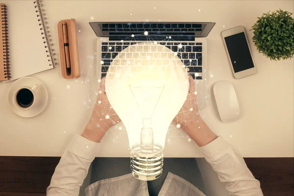 コンピュータと電球のホログラム描画に取り組んで女性の手の二重露出。トップビュー。アイデアのコンセプト. — ストック写真