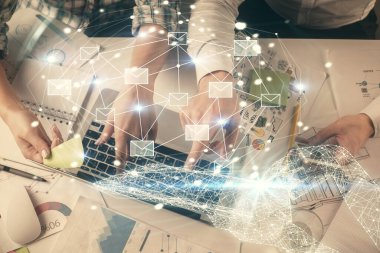Birlikte çalışan kadın ve erkeğin çifte pozu ve hologram çizimi. Bilgisayar arkaplanı. Üst Manzara. Elektronik posta kavramı.