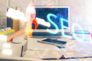 Bilgisayar ve seo çizim hologramı olan bir masanın çifte görüntüsü. Arama optimizasyon kavramı.