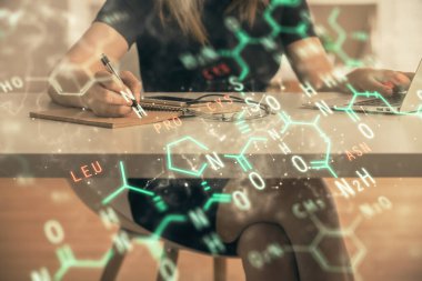 Bilgisayarda ve formüllü hologram çizimlerinde kadın elinin çifte pozu. Eğitim kavramı.