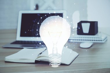 Bilgisayar ofisinde ampul simgesi hologramıyla birlikte. Çoklu maruz kalma. Fikir kavramı.