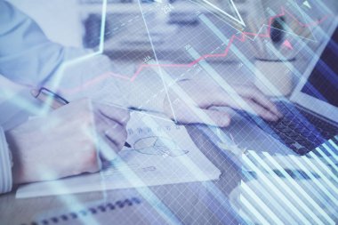 Arka planda dizüstü bilgisayar üzerinde çalışan adam ile borsa grafiği çoklu pozlama. Finansal analiz kavramı.