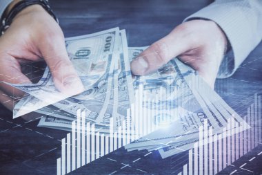 Finansal grafiğe çoklu pozlama hologram, Amerikan dolarları ve insan eli. Analiz kavramı.