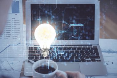 Bilgisayar ofisinde ampul simgesi hologramıyla birlikte. Çoklu maruz kalma. Fikir kavramı.