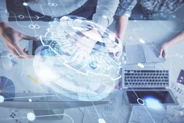 Kadın ve erkeğin birlikte çalışması ve veri temalı hologram çizimi. Bilgisayar arkaplanı. Üst Görünüm.