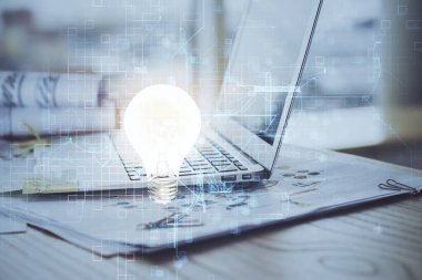 Bilgisayar ofisinde ampul simgesi hologramıyla birlikte. Çoklu maruz kalma. Fikir kavramı.