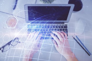Erkeklerin ellerinin bilgisayar klavyesini ve dünya haritası hologramını yazarken çoklu pozlama. Üst Manzara. Teknoloji konsepti.