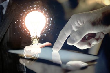 Dijital bir cihaz ve ampul hologram çizimi kullanarak erkeklerin ellerini tutarken çift pozlama. Fikir kavramı.