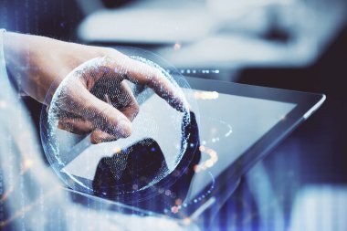 Erkeklerin el ele tutuşup dijital bir cihaz ve harita çizimine maruz kalmışlar. Uluslararası iş kavramı.