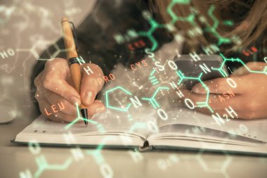 Bilgisayarda ve formüllü hologram çizimlerinde kadın elinin çifte pozu. Eğitim kavramı.