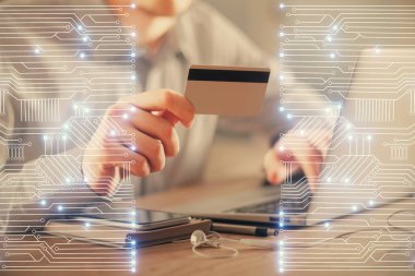 Elinde kredi kartı ve teknik tema çizimi olan bir adamın ellerine iki kez maruz kalmış. E-ticaret teknolojisi kavramı.