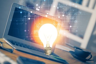 Bilgisayar ofisinde ampul simgesi hologramıyla birlikte. Çoklu maruz kalma. Fikir kavramı.