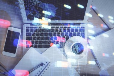 Bilgisayarla üst görünüm çalışma masası arka planında veri temasının çoklu pozlanması hologramı çiziyor. Teknoloji kavramı.