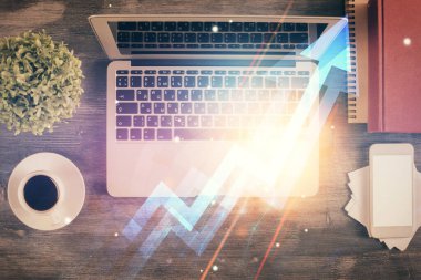 Masaüstü arkaplanındaki bilgisayarın üzerinden hologram çizimleri okluyor. Üst Manzara. Çifte maruziyet. Büyüme kavramı.