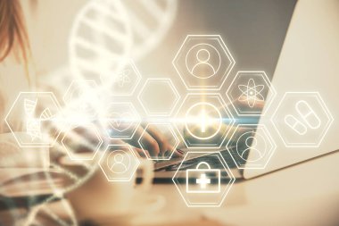 Bilgisayarda yazı yazan ve DNA hologramı çizen bir kadının ellerine iki kez maruz kalmış. Tıp eğitimi kavramı.
