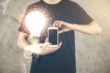 Dijital bir cihaz ve ampul hologram çizimi kullanarak erkeklerin ellerini tutarken çift pozlama. Fikir kavramı.