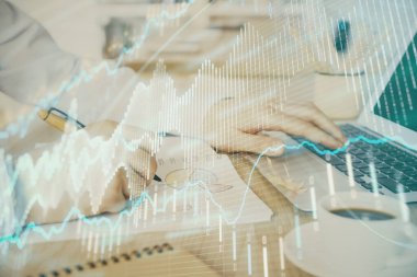 Arka planda dizüstü bilgisayar üzerinde çalışan adam ile borsa grafiği çoklu pozlama. Finansal analiz kavramı.