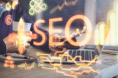 Erkeklerin el ele tutuşup dijital bir cihaz ve seo çizimi kullanırken birden fazla pozlama. arama optimizasyonu kavramı.