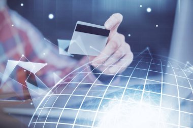 Elinde kredi kartı ve dünya haritası çizimi olan bir adamın ellerine iki kez maruz kalmış. Uluslararası İnternet E-ticaret ve teknoloji kavramı.