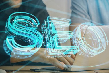 Arka planda bilgisayar üzerinde çalışan bir adamla birlikte çok sayıda simgeye maruz kalma. Arama motoru optimizasyonu kavramı.