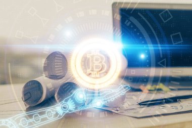 Engelleme zinciri ve kripto ekonomi temalı hologram ve bilgisayar geçmişi olan bir masa. Bitcoin kripto para kavramı.