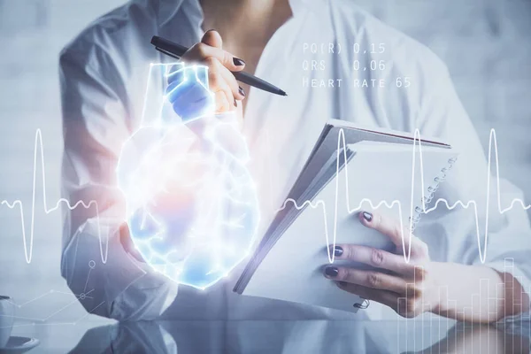 Heart hologram over womans hands writing background. Concept of Medical study. Multi exposure — Stock Photo, Image