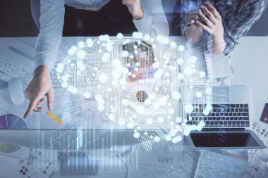 Kadın ve erkeğin birlikte çalışması ve insan beyin hologramı çizimi. Beyin fırtınası konsepti. Bilgisayar arkaplanı. Üst Görünüm.