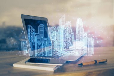 Ofisteki masaüstü bilgisayar geçmişi ve büyük kasaba binaları hologram çizimi. Çifte maruziyet. Akıllı şehir konsepti.