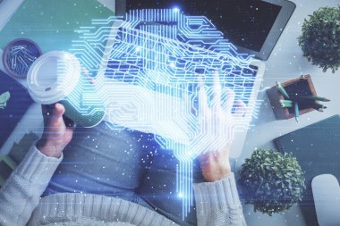 Bilgisayar ve insan beyin hologramı çizimleri üzerinde çalışan bir kadının çifte pozu. Üst Manzara. Ai kavramı.