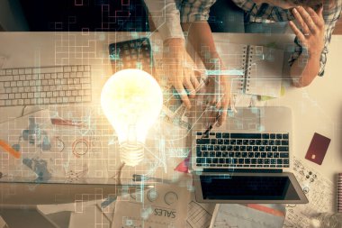 Kadın ve erkeğin birlikte çalışırken ve ampul çekerken çift pozlama. Bilgisayar arkaplanı. Üst Manzara. Fikir kavramı.