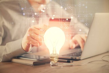 Elinde bir kredi kartı ve ampul çizimi olan bir adamın ellerine iki kez maruz kalmış. Fikir E-ticaret kavramı.