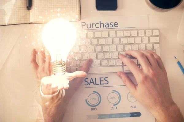 Double exposure of mans hands typing over computer keyboard and bulb hologram drawing. Top view. Idea concept. — Stock Photo, Image