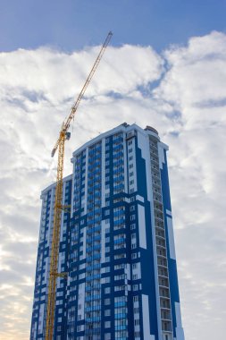 Mavi gökyüzüne karşı vinç ve inşaat alanı