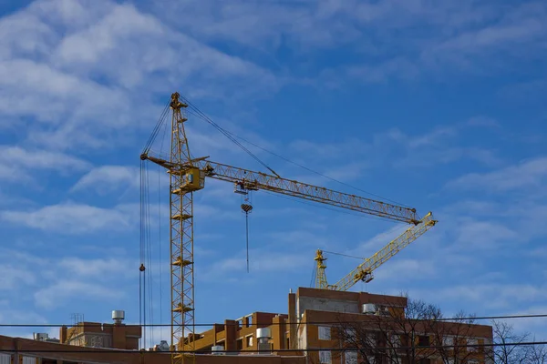Mavi gökyüzüne karşı vinç ve inşaat alanı