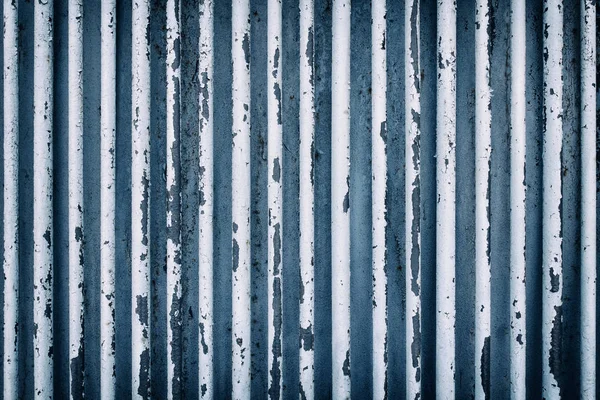 Boru oluşan bir eski paslı çit. Mavi tonları