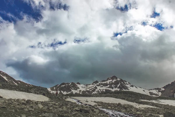 Kasvetli gökyüzü. Yalnız turist Nehri boyunca tepeye gider