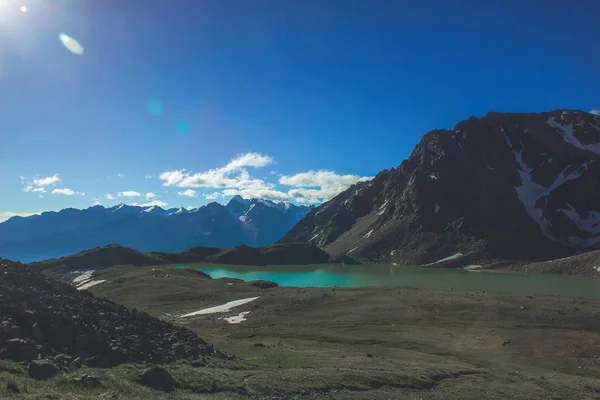 Vista desde el paso hasta el magnífico lago en las montañas del Cáucaso. Cerca hay tiendas de campaña — Foto de Stock