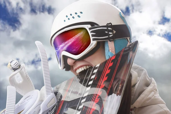 Young girl snowboarder in helmet and goggles bites snowboard — Stock Photo, Image